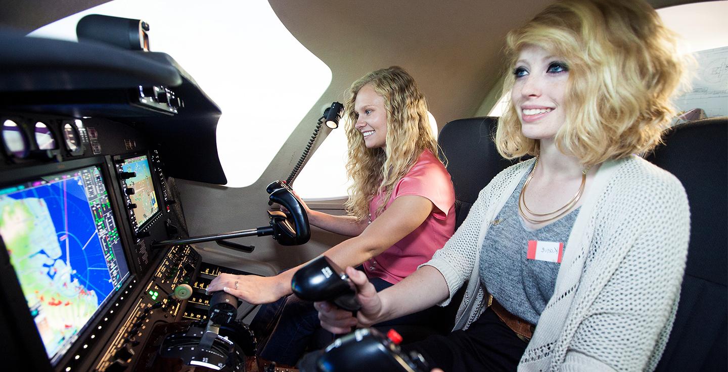 Two students operate a flight simulator