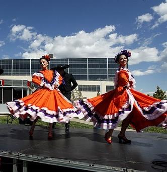 Two folklorico dancers in traditional folklorico dresses